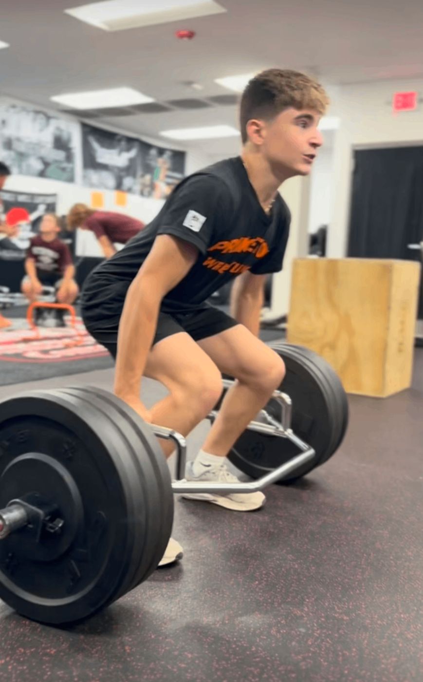 High school athlete setting up for a trap bar deadlift